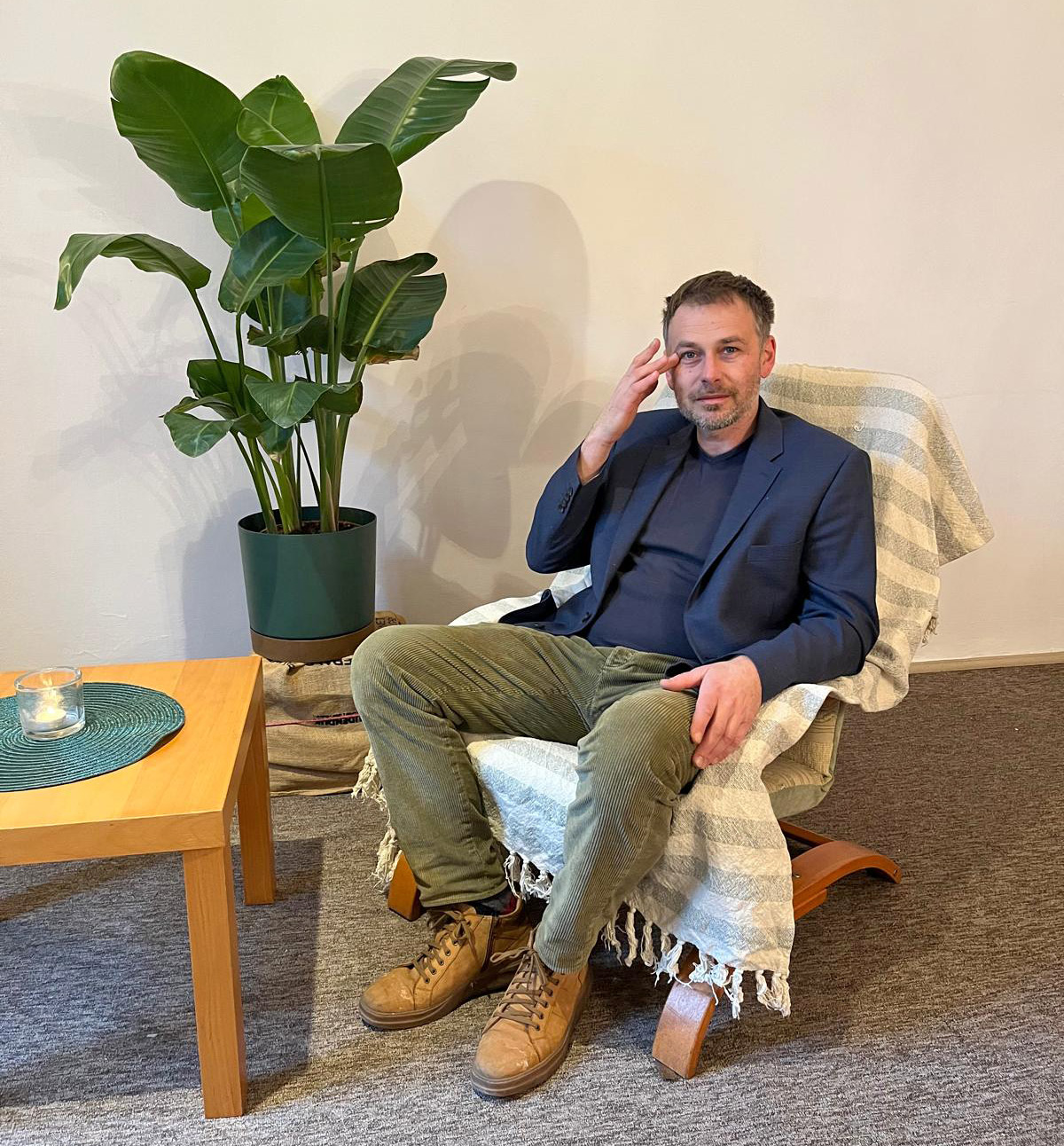 Therapist takes notes as client sits on a sofa during a psychotherapy session.